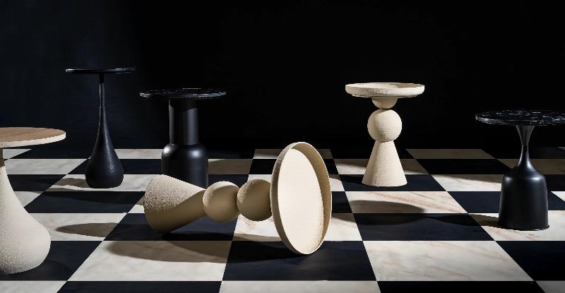 Une sculpture abstraite en pierre de savon aux formes organiques et douces, posée sur un socle en bois